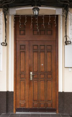 Modern ahşap kapılı ve güneşlikli bir bina.