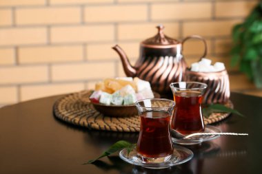 Bir bardak Türk çay ve yapraklı çay tabağı odada, yakın plan.