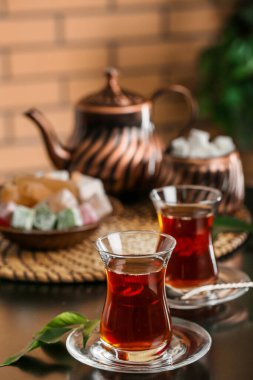 Bir bardak Türk çay ve yapraklı çay tabağı odada, yakın plan.