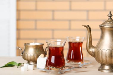 Bir bardak Türk çayı ve tatlısıyla fincan tabağı masada, yakın plan.