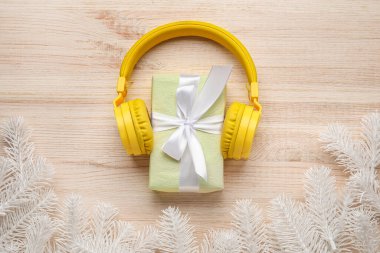 Modern kulaklıklı kompozisyon, Noel hediyesi ve ahşap arka planda köknar dalları