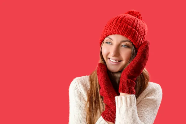 戴着暖帽 头戴红色背景手套的年轻女子 — 图库照片