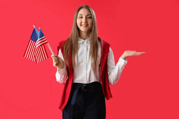 Piękna Kobieta Flagą Usa Pokazuje Coś Czerwonym Tle — Zdjęcie stockowe
