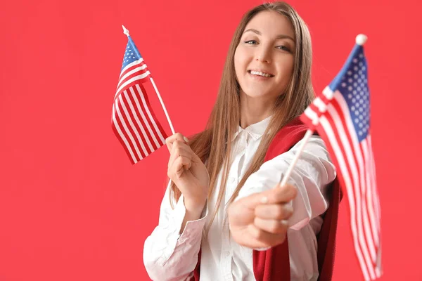 赤の背景にアメリカの旗を持つ美しい女性 — ストック写真