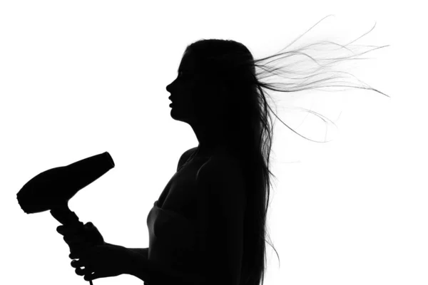 白色背景的带吹风机的年轻妇女的轮廓 — 图库照片