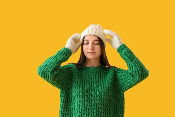 Sarı Arka Planda Yeşil Süveterli Kalın Şapkalı Genç Bir Kadın — Stok fotoğraf