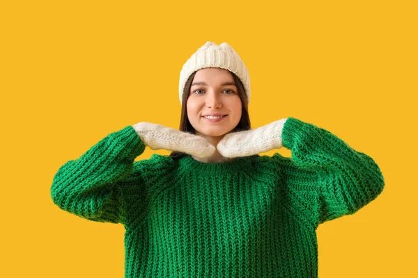 头戴暖帽 身穿黄色背景绿色毛衣的年轻女子 — 图库照片