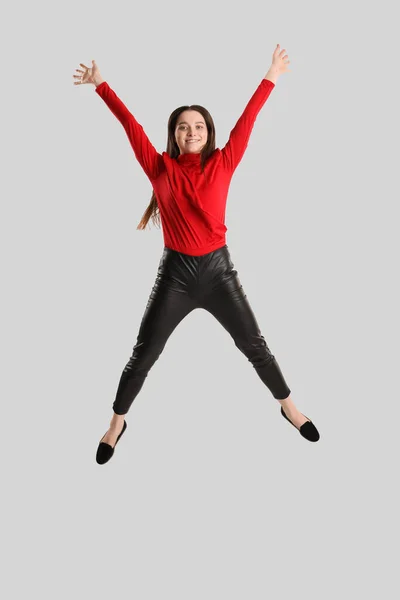 Mujer Morena Joven Pantalones Cuero Saltando Sobre Fondo Gris — Foto de Stock