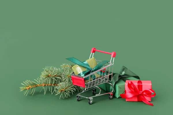 Kundvagn Med Julen Grenar Och Presenter Grön Bakgrund — Stockfoto