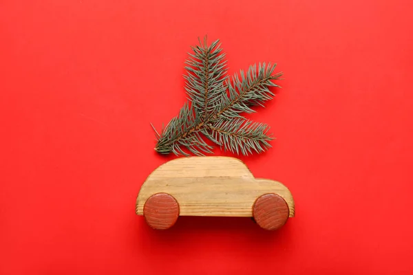 Zabawka Samochód Gałęzi Bożego Narodzenia Czerwonym Tle — Zdjęcie stockowe