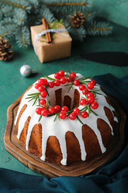 Yeşil arka planda lezzetli Noel pastası olan ahşap tahta, yakın plan.