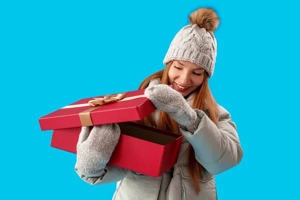 Young Woman Opening Christmas Present Blue Background — Stock Photo, Image