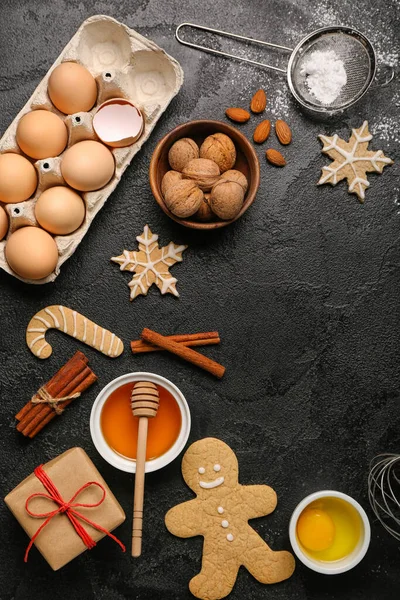 Composition with tasty Christmas cookies and ingredients on dark background