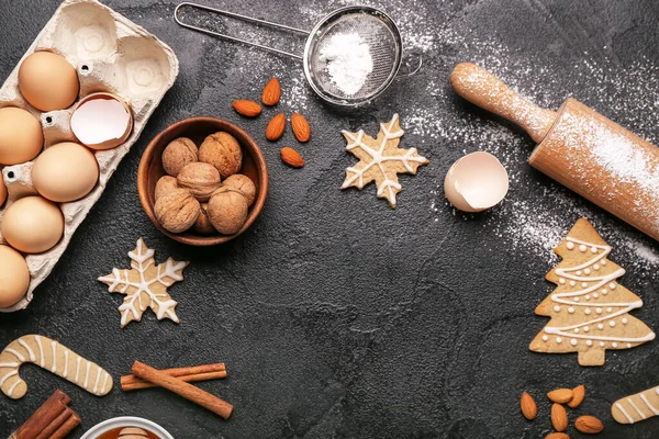 Composition with tasty Christmas cookies and ingredients on dark background, closeup