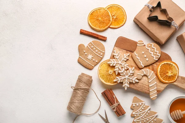Composition with tasty Christmas cookies,gift and orange slices on light background