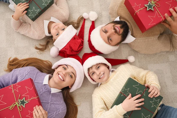Família Feliz Chapéus Papai Noel Com Presentes Natal Deitado Chão — Fotografia de Stock