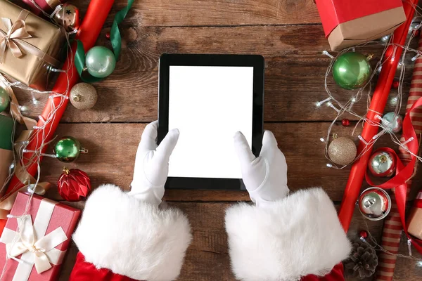 Jultomten Håller Tablett Dator Träbord Med Juldekor Och Presenter Ovanifrån — Stockfoto