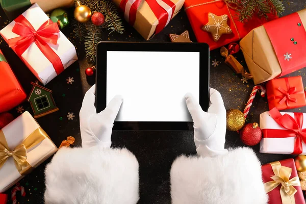 Jultomten Håller Tablett Dator Bordet Med Juldekor Och Presenter Ovanifrån — Stockfoto