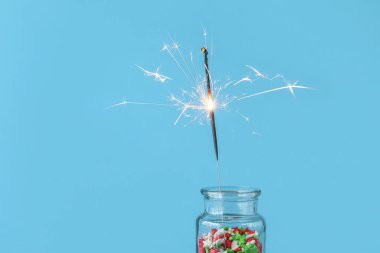 Renkli arka planda yılbaşı maytaplarıyla dolu renkli bir kavanoz.