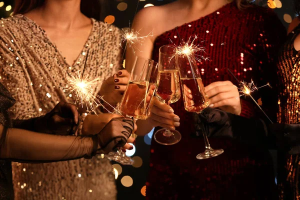 Unga Kvinnor Eleganta Klänningar Med Brinnande Julglitter Och Glas Champagne — Stockfoto