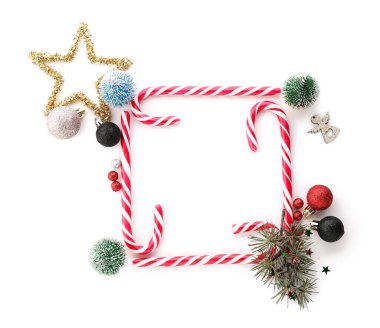 Lezzetli baston şekerlerden yapılmış çerçeve ve beyaz arka planda Noel süslemeleri