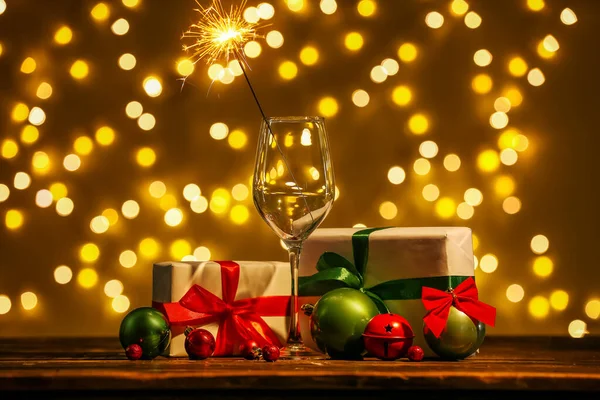 クリスマスの輝きを持つガラス ぼやけた光に対するテーブルの上の贈り物やボール — ストック写真