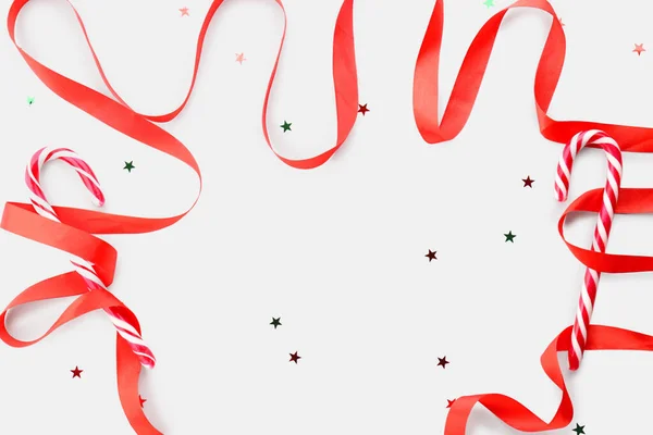 Komposition Mit Roter Schleife Und Leckeren Zuckerstangen Auf Weißem Hintergrund — Stockfoto