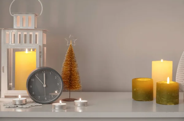 Wecker Mit Weihnachtslaterne Und Brennenden Kerzen Regal Neben Lichtwand — Stockfoto
