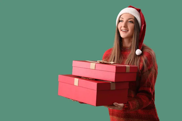 Молода Жінка Санта Капелюшці Різдвяними Подарунками Зеленому Фоні — стокове фото
