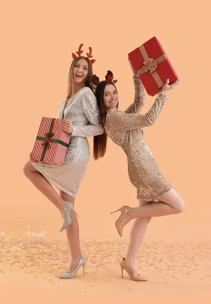 Mujeres Jóvenes Cuernos Reno Con Regalos Navidad Sobre Fondo Beige — Foto de Stock