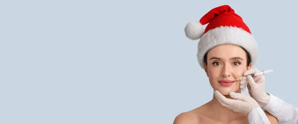 Young Woman Santa Hat Receiving Filler Injection Lips Light Background — Stock Photo, Image