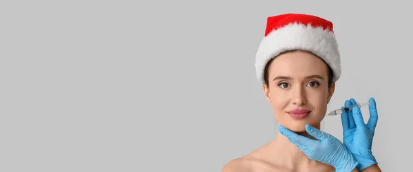 Young Woman Santa Hat Receiving Filler Injection Grey Background Space — Stock Photo, Image
