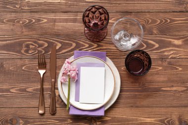 Boş kartlı masa ayarı ve tahta arka planda sümbül çiçeği