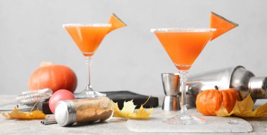 Gri arkaplanda bir bardak lezzetli balkabağı turtası martini.