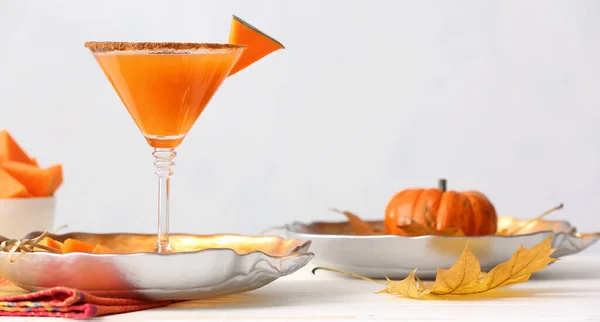 stock image Glass of tasty pumpkin pie martini on table against light background