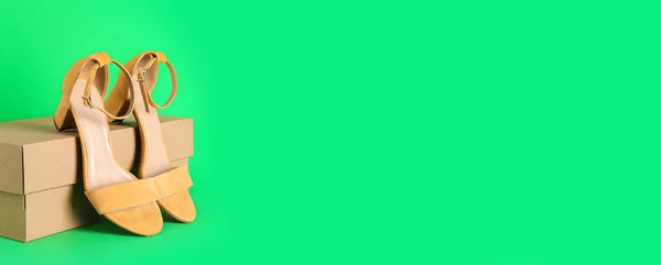 Caixa Papelão Sandálias Amarelas Fundo Verde Com Espaço Para Texto — Fotografia de Stock