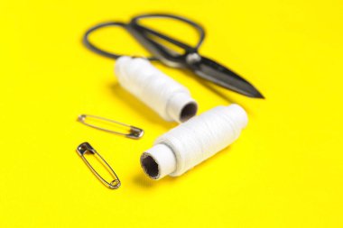 Sarı arkaplanda beyaz iplik makaraları, yakın plan