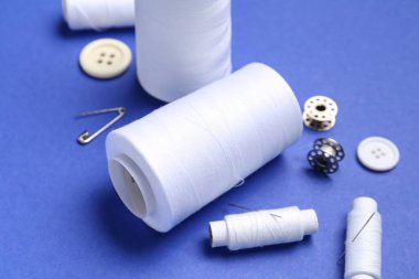 Renk arkaplanında iplik makaraları dikiliyor, yakın plan