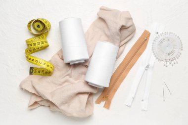 Işık arkaplanında iplik makaralı dikiş aksesuarları