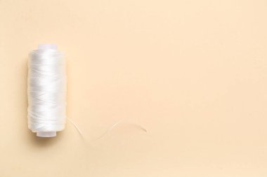 Renk arkaplanında beyaz iplik makarası