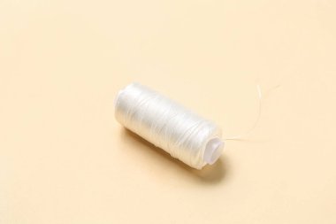 Renk arkaplanında beyaz iplik makarası