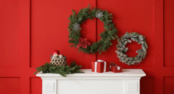 Красивые Рождественские Венки Висят Красной Стене Рядом Камином Комнате — стоковое фото