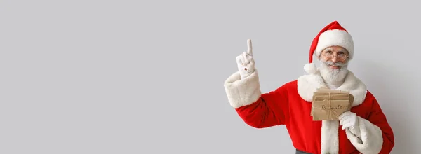Weihnachtsmann Mit Buchstaben Die Auf Etwas Auf Grauem Hintergrund Zeigen — Stockfoto