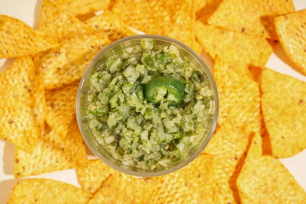 Bowl of tasty green salsa sauce and nachos, closeup