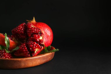 Koyu arkaplanda taze nar tabağı.