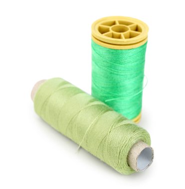 Beyaz arkaplanda yeşil iplik makaraları izole edildi