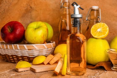 Bir şişe elma sirkesi ve renkli arkaplanda meyveler