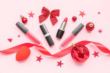 Pembe arka planda Noel dekoru olan rujlar.