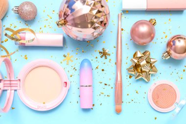 Mavi arka planda Noel dekoru olan makyaj ürünleri