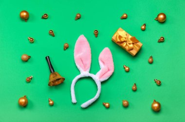 Noel çanlı tavşan kulakları, toplar ve yeşil arka planda hediye